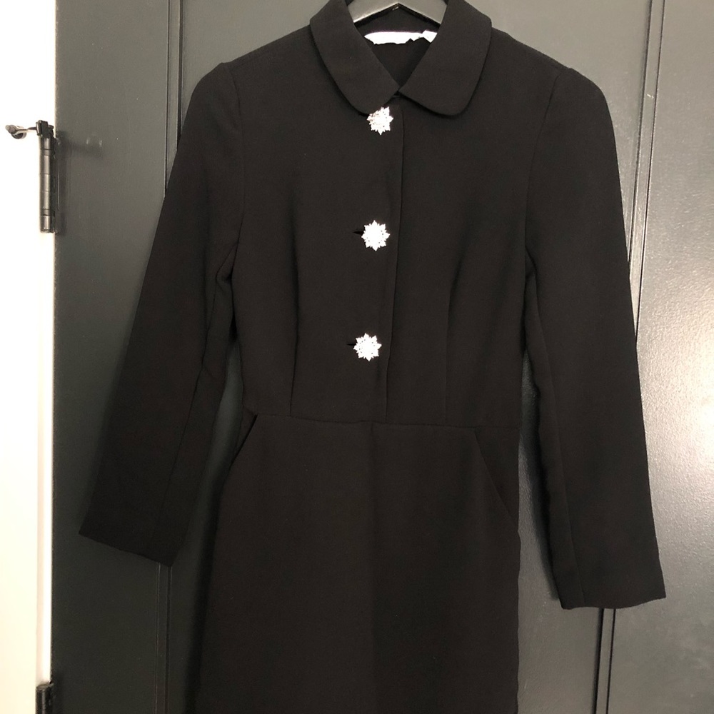 Black dress with diamond buttons .